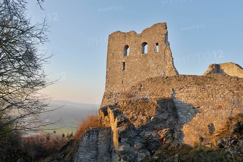 Mighty castle ruins on a hill in the evening sun, surrounded by landscape and trees, Wolfstein castle ruins, Neumarkt in der Upper Palatinate