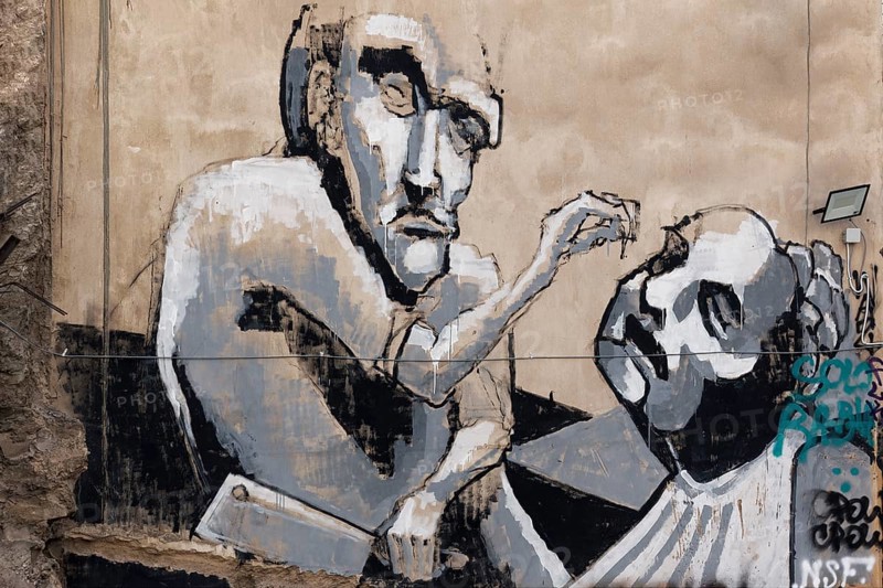 Figure with cleaver rips out man's tooth, graffiti in Exarchia, neighbourhood of students and alternative scene, Athens, Greece, Europe