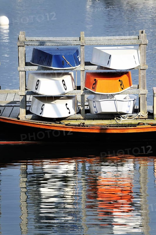 Six colorful blue, orange and white wooden dinghy sailboats stored for the evening, Rockland Maine USA