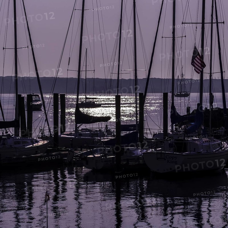 Sailboats in silhouette at anchor with a purple sunrise. Niantic, East Lyme, Connecticut, New England, USA, North America