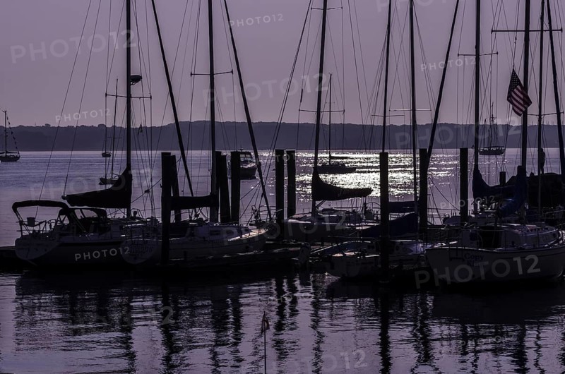 Sailboats in silhouette moored at a dock with a purple sunrise. Niantic, East Lyme, Connecticut, New England, USA, North America