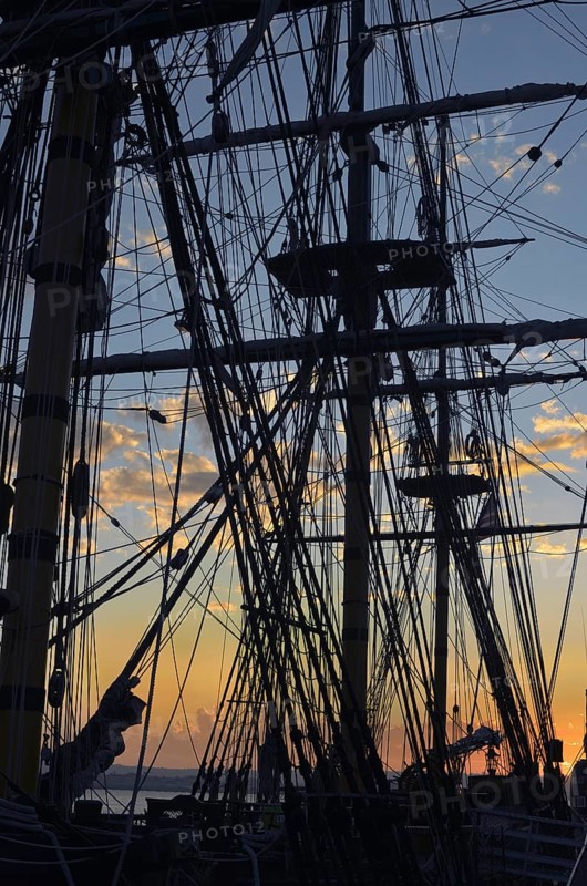 San Diego, California, USA, Sunset seen through the silhouette of the HMS Surprise, a replica of a British frigate purchased by the San Diego Maritime Museum after it was used in the film Master and Commander The Far Side of the World, North America
