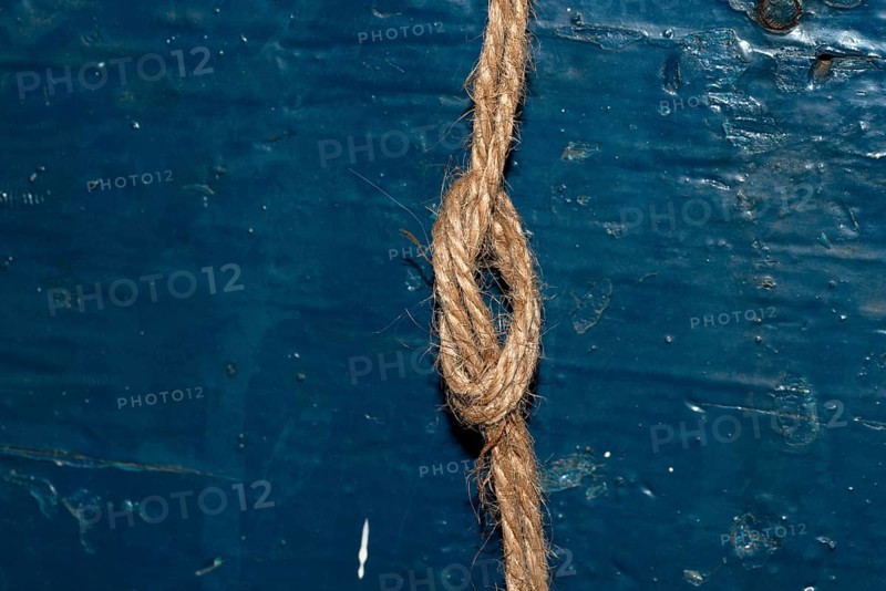 Nautical rope knot on blue wooden background