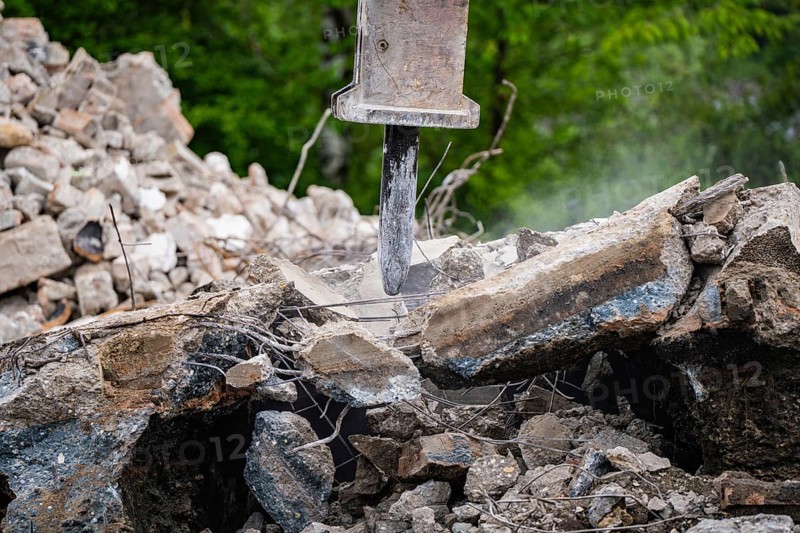 Excavator breaks up concrete and rubble and dust can be seen on a construction site, Demolition construction site, Saarbrücken, Germany, Europe