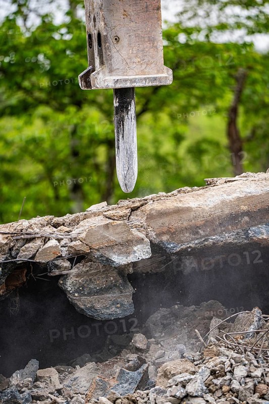 Close-up of the excavator as it breaks up concrete on a construction site. Debris and dust are visible, demolition site, Saarbrücken, Germany, Europe