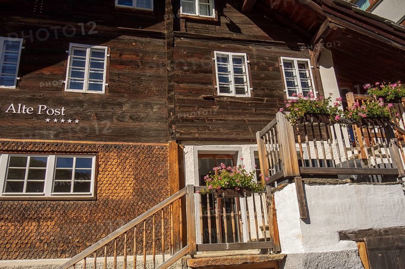 Rustic wooden house with flowers in pots on the stairs and window sills, Saas Fee, Switzerland, Europe