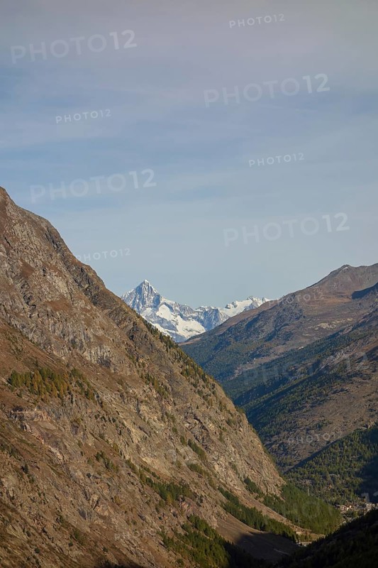 A narrow mountain gorge with snow-capped peaks in the background, Saas Fee, Switzerland, Europe