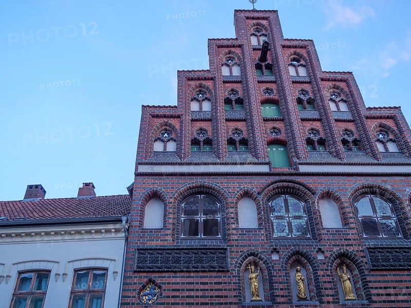 A historic brick building with an elaborately decorated faÃ§ade and many windows against a blue sky, Lüneburg, Lower Saxony, Germany, Europe