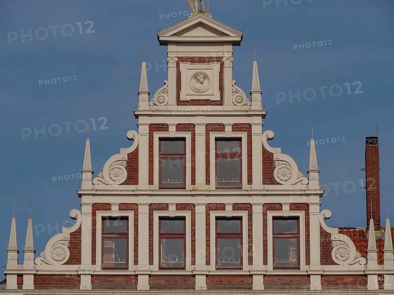 Decorative gable of a building with white decorations and windows, lüneburg, germany