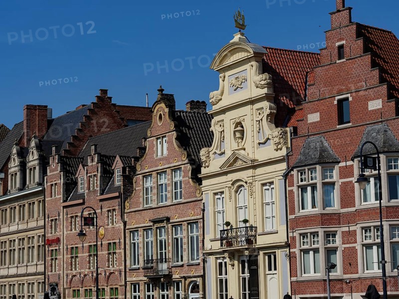 Row of old brick buildings with distinctive gables and window frames on a sunny day, gent, belgium
