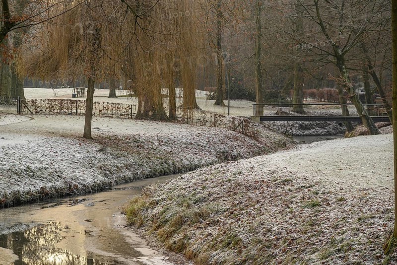 Frost-covered trees and grass surround a small river with a bridge in a wintry park, Velen, North Rhine-Westphalia, GERMANY