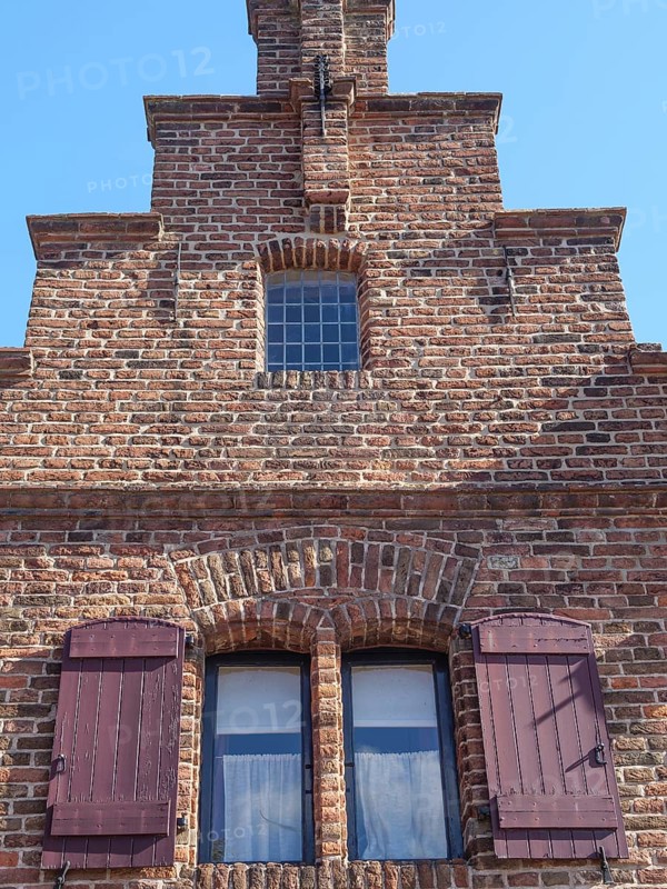 Close-up of a historic brick building with striking window sills and shutters, Doesburg, Netherlands