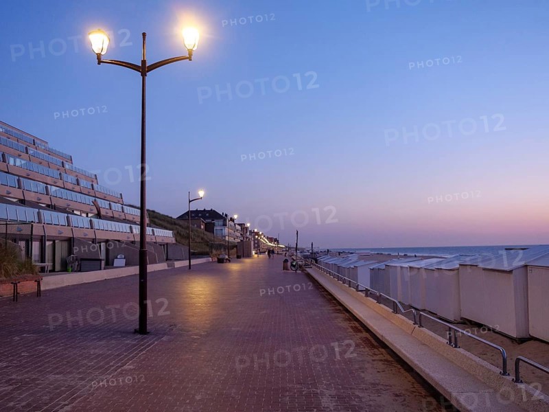 Dusk on a quiet beach promenade with glowing lanterns, de haan, Belgium, Europe