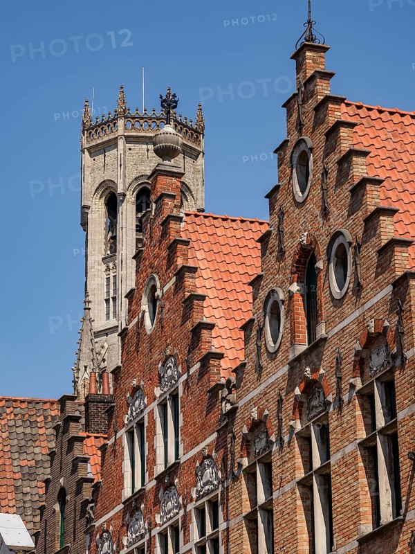Historic brick buildings with ornate facades and a tall tower in the background, Bruges, Belgium, Europe