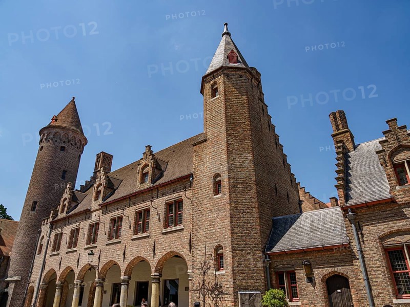 A medieval castle with high towers and an archway, Bruges, Belgium, Europe