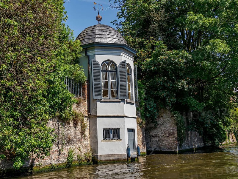Pavilion by the river, surrounded by trees and a brick wall, peaceful atmosphere, Bruges, Belgium, Europe