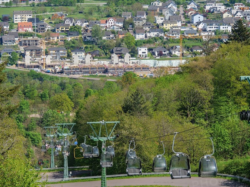 Cable car over a cityscape with hills and green trees under a blue sky, Saarburg, Germany, Europe