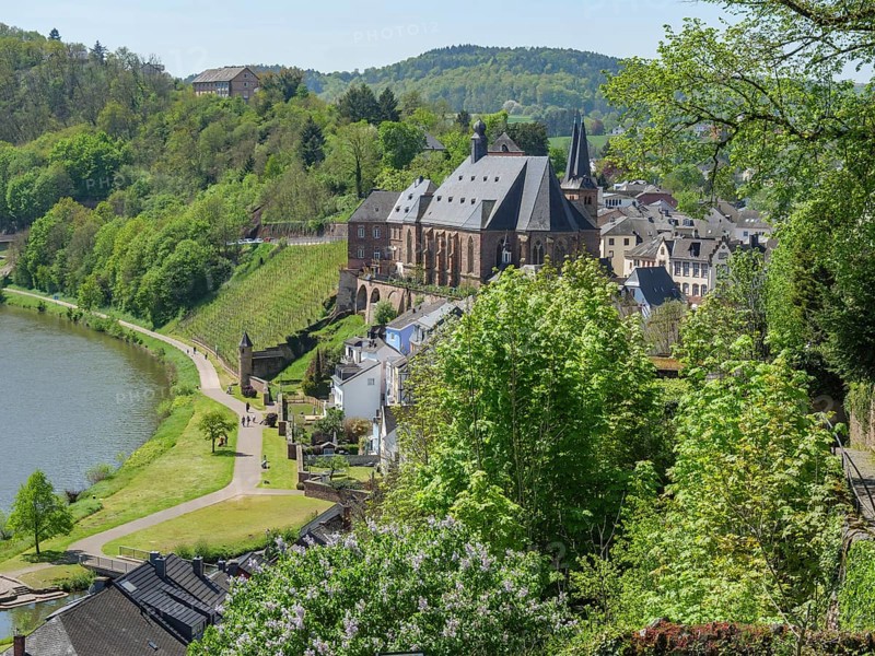 Idyllic view of a town with a river and green hills with historic buildings, Saarburg, Germany, Europe