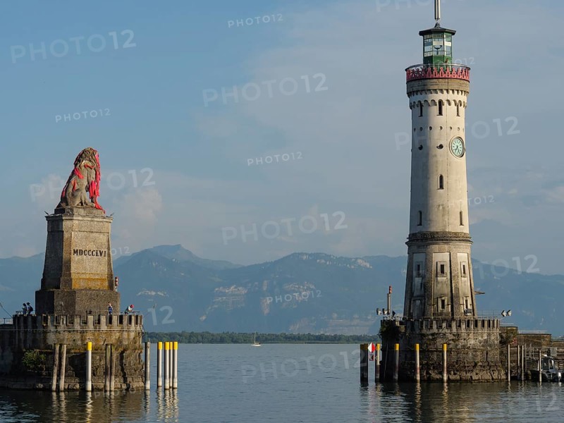 Lighthouse and lion statue at the entrance of a harbour, mountain landscape in the background, Lindau, Lake Constance, Germany, Europe