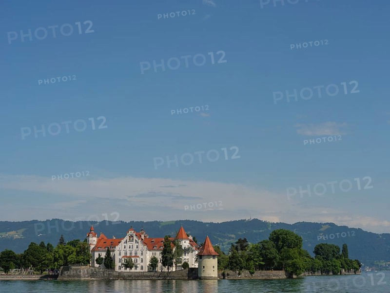 A castle on an island in the lake with mountains and blue sky in the background, Lindau, Lake Constance, Germany, Europe