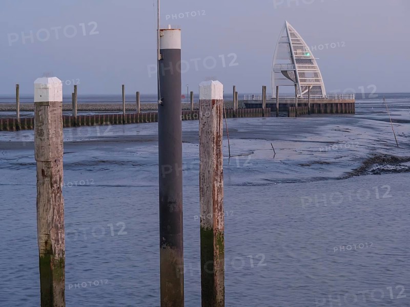 A modern harbour with wooden bollards and a building in the background at dusk, Juist, East Frisia, Germany, Europe