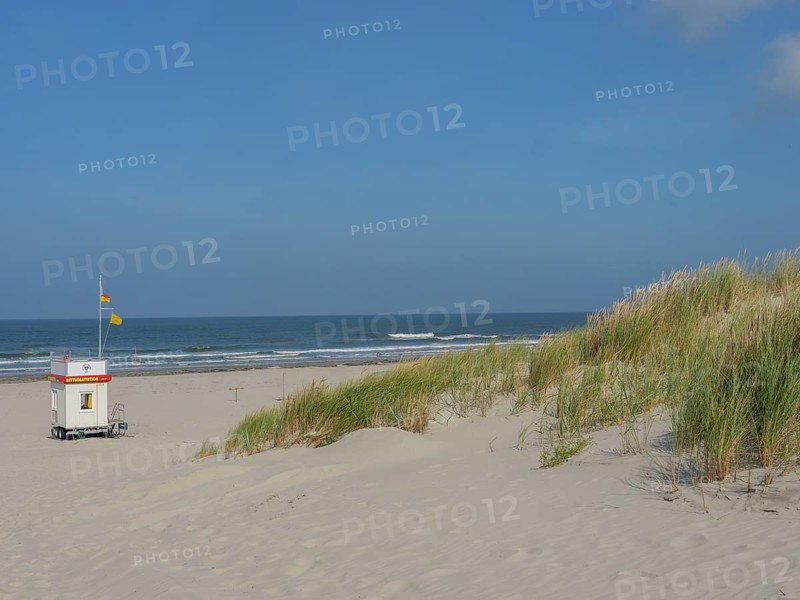 Small hut with flag on a wide sandy beach with dunes and blue sky, Juist, East Frisia, Germany, Europe