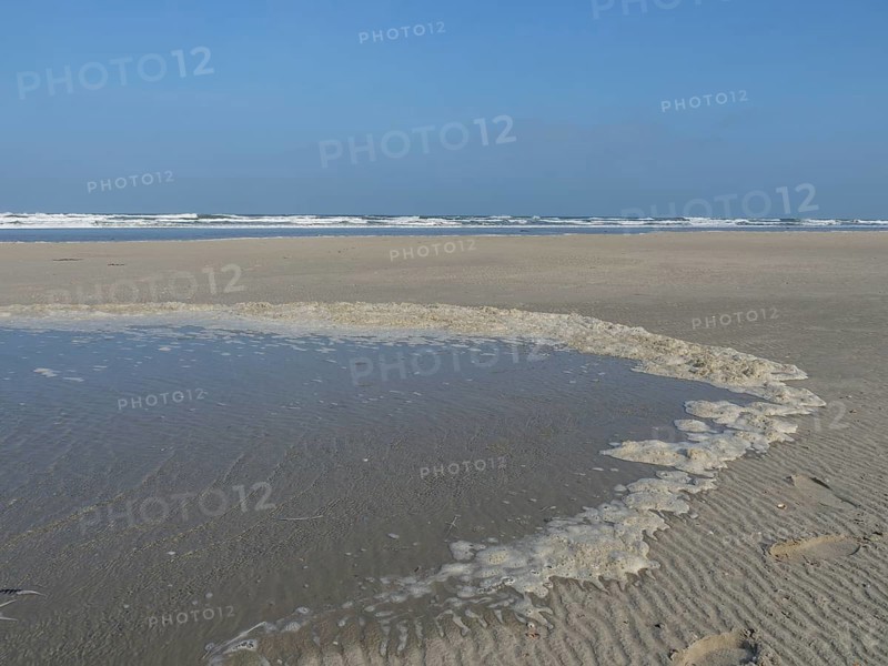 A wide, sandy shore with water accumulations and the sea in the background, juist, east frisia, germany