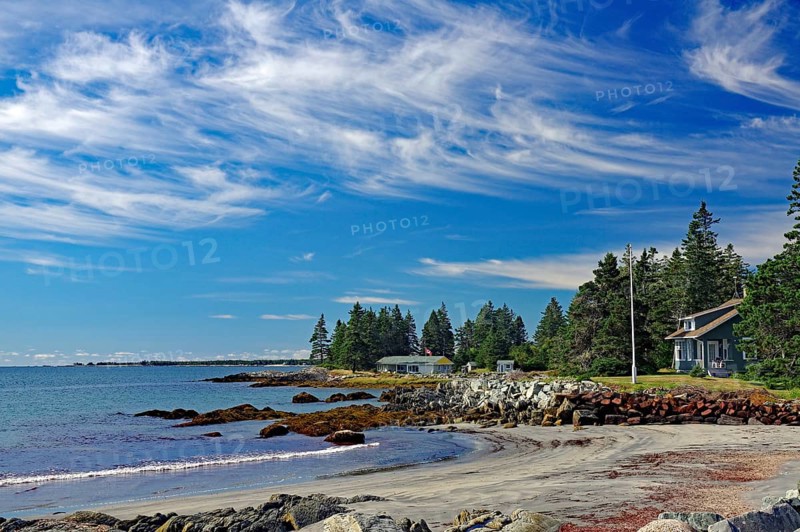 A quiet beach with blue sky, white clouds, sea, sand, rocks, trees and few houses on the coast, late summer, Cherry Hill Beach, Nova Scotia, Canada, North America