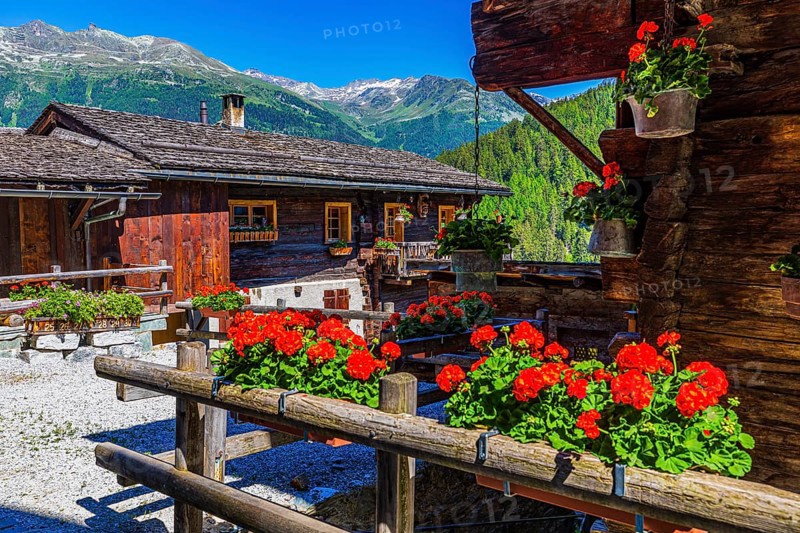 Old wooden house with floral decorations on windows and terrace, historic village centre, Grimentz, Val d'Anniviers, Valais Alps, Canton Valais, Switzerland, Europe