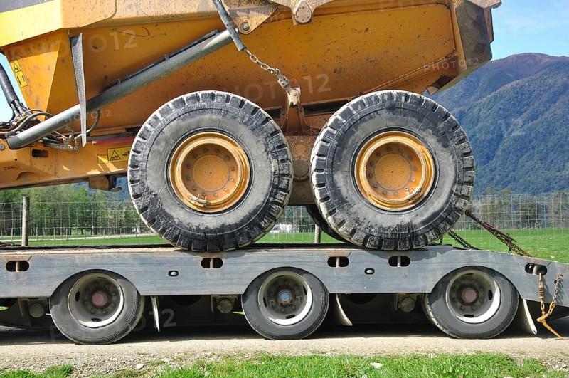 Detail of the wheels of a 30 ton dump truck loaded on a semi-trailer