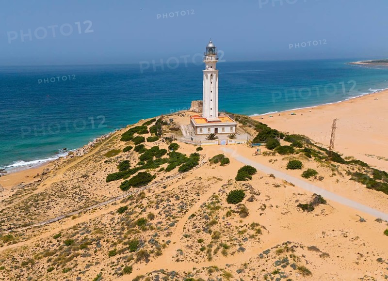 Lighthouse on a coastline with a view of the wide sea and the beach under a clear sky, aerial view, Faro de Trafalgar, Cape Trafalgar, Cadiz province, Costa de la Luz, Andalucia, Spain, Europe