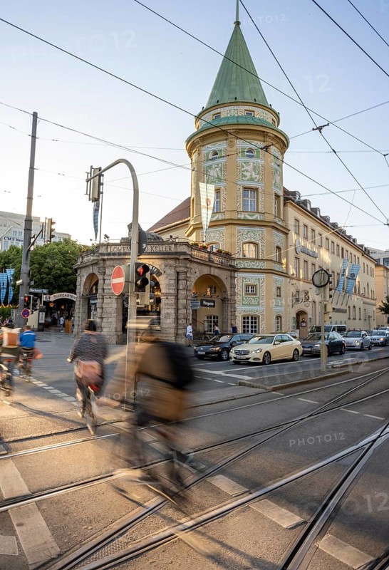 Cyclists crossing the traffic light at red at Stiglmaierplatz, motion blur, Löwenbräukeller of the Löwenbräu brewery in the background, Stiglmaierplatz, Munich, Upper Bavaria, Bavaria, Germany, Europe