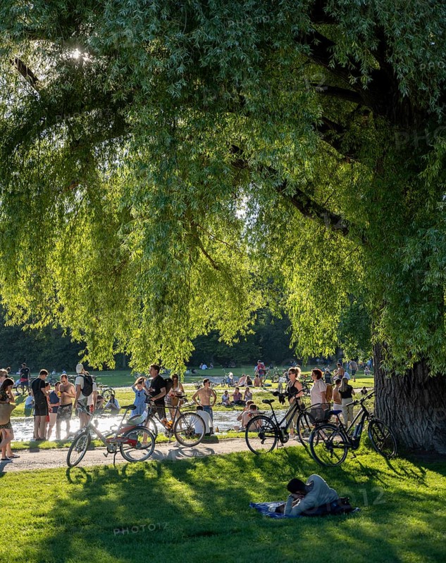Large meadow at Schwabinger Bach, Many people on a summer day in the English Garden, Munich, Bavaria, Germany, Europe