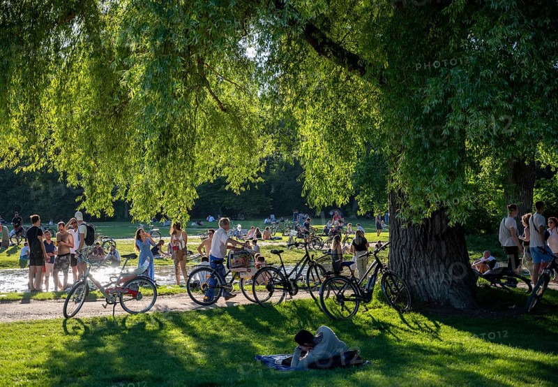 Large meadow at Schwabinger Bach, Many people on a summer day in the English Garden, Munich, Bavaria, Germany, Europe