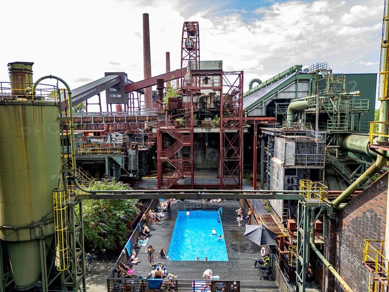 The works swimming pool at the Zollverein coking plant, always in operation during the North Rhine-Westphalia summer holidays, former art object, now bathing fun against the backdrop of what was once Europe's largest central coking plant, closed in 1993, part of the UNESC World Heritage Zollverein Coal Mine Industrial Complex, Essen, North Rhine-Westphalia, Germany, Europe