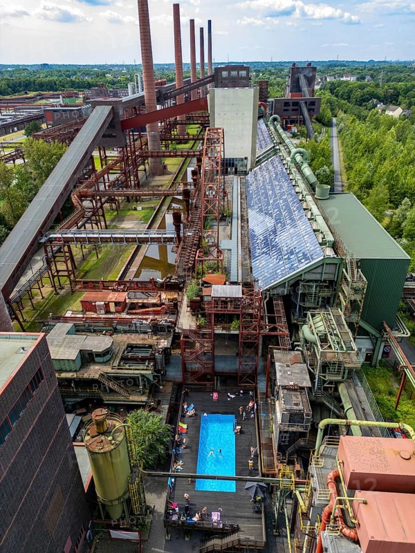 The works swimming pool at the Zollverein coking plant, always in operation during the North Rhine-Westphalia summer holidays, former art object, now bathing fun against the backdrop of what was once Europe's largest central coking plant, closed in 1993, part of the UNESC World Heritage Zollverein Coal Mine Industrial Complex, Essen, North Rhine-Westphalia, Germany, Europe