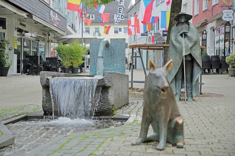 Sculptures Shepherd fountain Cow herd with shepherd by Wolfgang Kreutter 1986, bronze, shepherd with staff, fountain, water jet, dog figure, shepherd dog, shepherd dog, sitting, pedestrian zone, Alte Poststrasse, Siegen, Siegerland, North Rhine-Westphalia, Germany, Europe