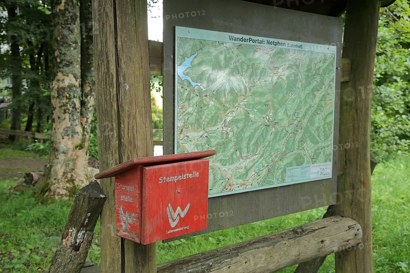 Red stamp with hiking sign on the Lahnwanderweg trail at the source of the Lahn with symbol, sign, map, hiking trail, hiking map, wooden box, Lahn, source of the Lahn, Lahnhof, Netphen, Rothaargebirge, Siegerland, North Rhine-Westphalia, Germany, Europe
