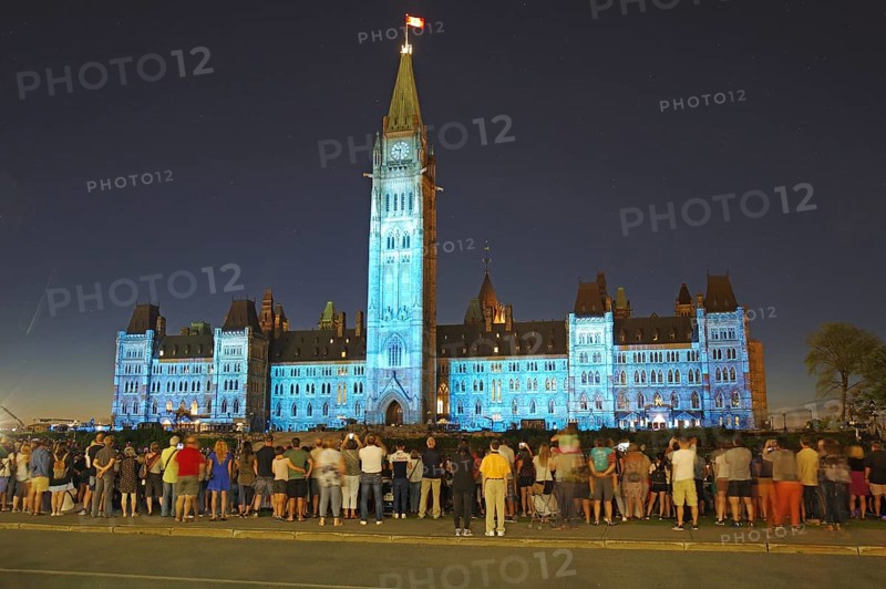 Night event with people in front of an illuminated historical building, laser show in front of the Parliament, Ottawa, Ontario, Canada, North America