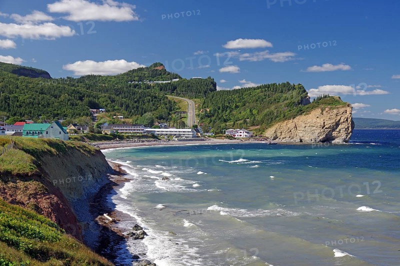 Coastal landscape with hills, cliffs and houses, the sea and waves under a clear blue sky, Perce, St. Lawrence River, Gaspesie, Quebec, Canada, North America