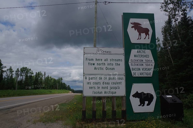 Road sign and traffic signs in a rural wooded area on a cloudy day, watershed, Manitoba, Canada, North America