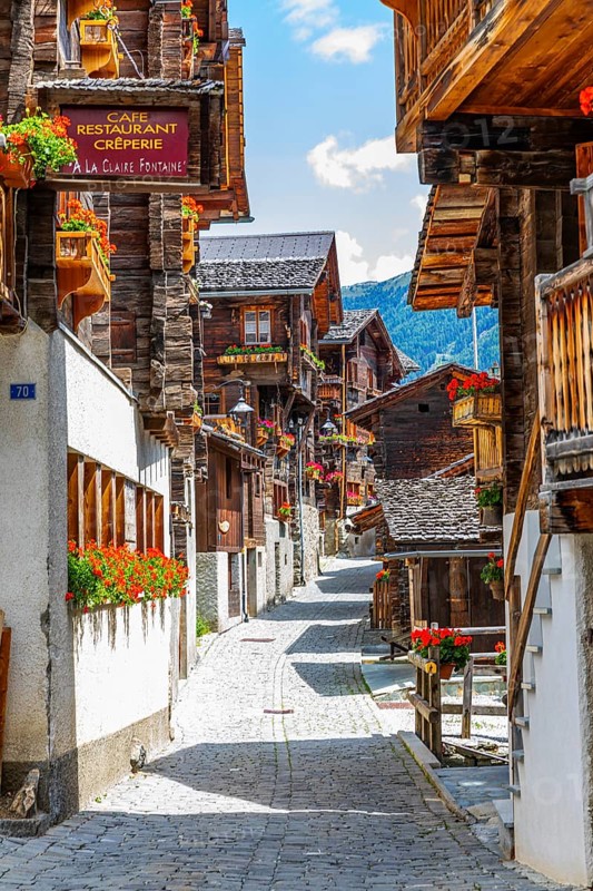 Paved footpath surrounded by old wooden houses, flower boxes on balconies and windows, historic village centre, Grimentz, Val d'Anniviers, Valais Alps, Canton Valais, Switzerland, Europe