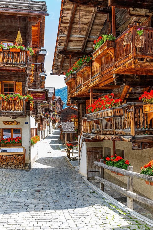 Paved footpath surrounded by old wooden houses, flower boxes on balconies and windows, historic village centre, Grimentz, Val d'Anniviers, Valais Alps, Canton Valais, Switzerland, Europe