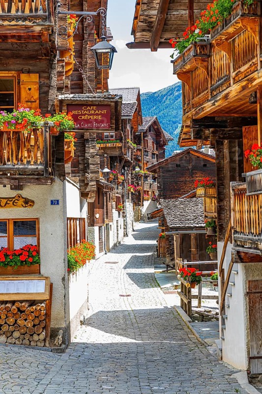 Paved footpath surrounded by old wooden houses, flower boxes on balconies and windows, historic village centre, Grimentz, Val d'Anniviers, Valais Alps, Canton Valais, Switzerland, Europe