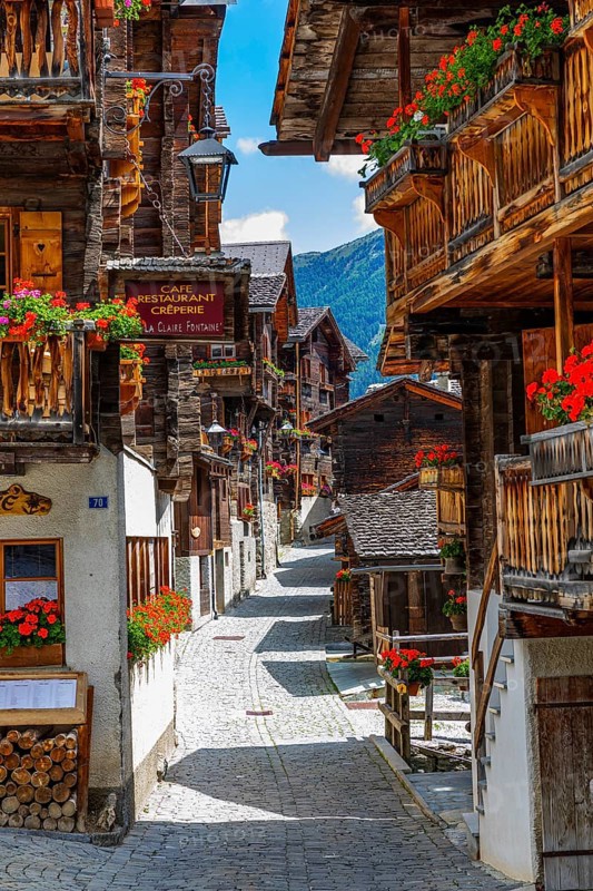 Paved footpath surrounded by old wooden houses, flower boxes on balconies and windows, historic village centre, Grimentz, Val d'Anniviers, Valais Alps, Canton Valais, Switzerland, Europe