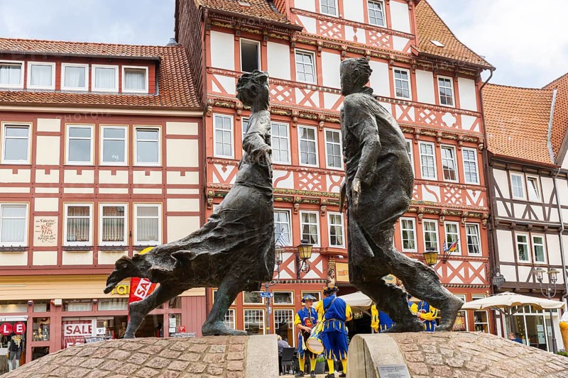 Duderstadt is a town and independent municipality in the district of Göttingen in south-east Lower Saxony. The predominantly medieval townscape is characterised by around 600 town houses of various styles - mainly half-timbered houses The town piper advertises the shooting festival. Reunification fountain Karl Henning Seemann 1996, Marktstrasse and historic Hotel zur Tanne, Duderstadt, Duderstadt, Lower Saxony, Germany, Europe