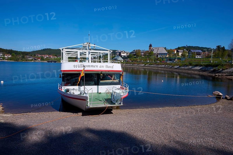 A boat with the inscription 'Welcome aboard' is anchored at the Schluchsee, in the background you can see houses and a blue sky, Schluchsee, Black Forest, Baden-Württemberg, Germany, Europe