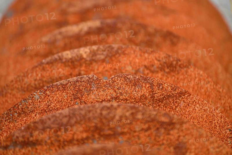 Grunge background of rusted plough shares on an old cultivator