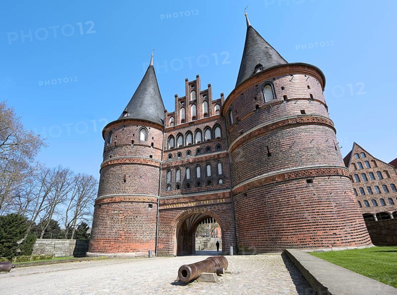 Lubeck Holstentor (Holsten gate) with canon, famous historic landmark with two round towers and an arched entrance to the hanseatic German city, gothic brick architecture from medieval times