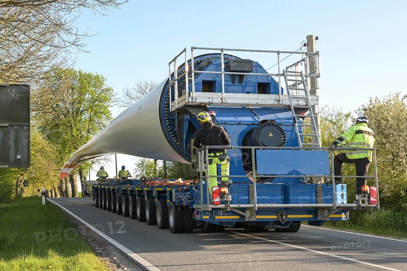 Heavy duty transport of a wind turbine blade on a narrow country road, industry concept for power and renewable energy, copy space, selected focus